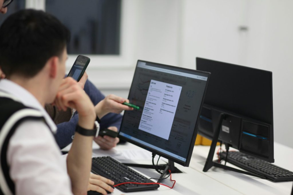 Eine Gruppe von Menschen sitzt an einem Tisch mit Computern